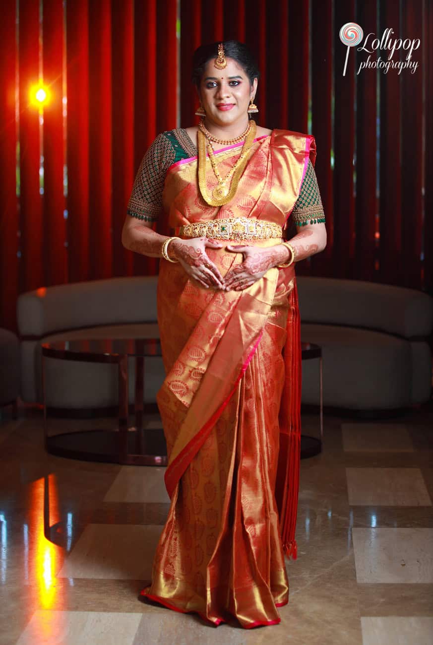 Expectant mother captured in a reflective moment, dressed in vibrant traditional attire during her baby shower celebration in Chennai.