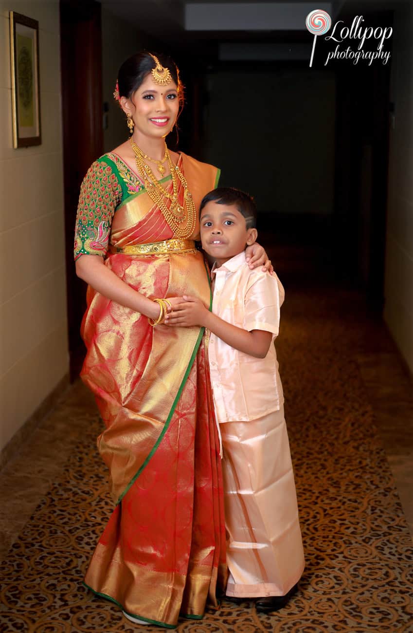 A mother in traditional attire captured in a warm hallway setting during a baby shower in Chennai.