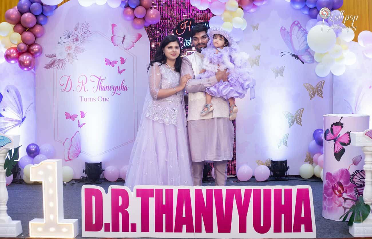 Family celebrating their daughter's first birthday in Chennai, with the birthday girl dressed in a beautiful lavender gown, complete with a family portrait by Lollipop Photography.