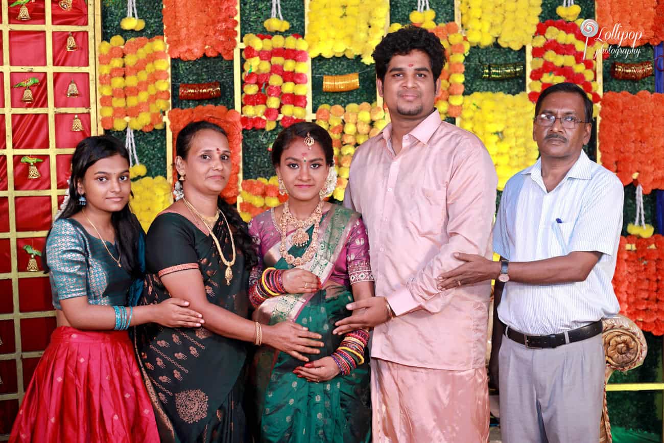 Extended family portrait during a baby shower celebration, highlighting the joyous occasion with vibrant decorations and traditional South Indian attire in Coimbatore.