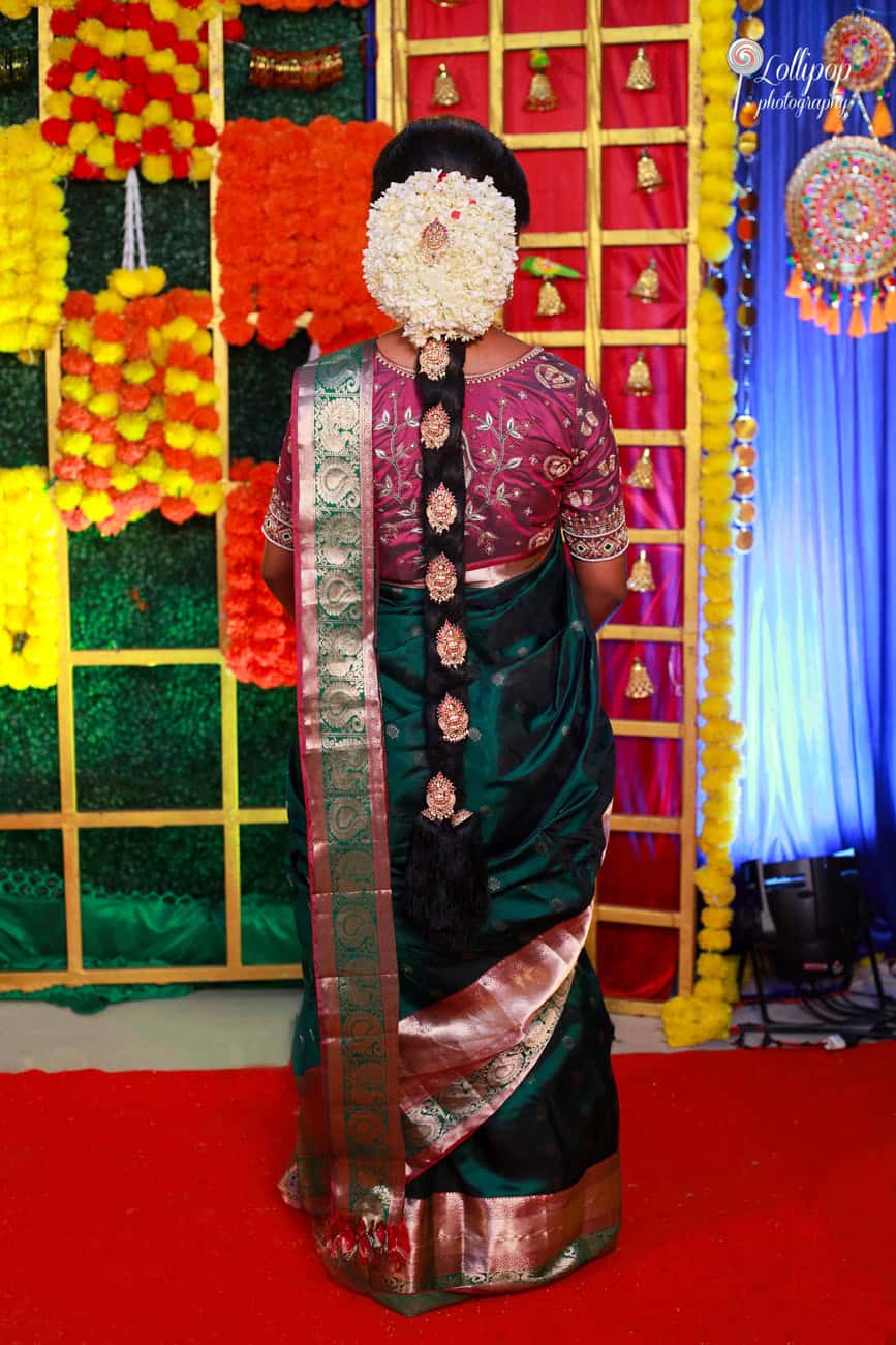 Maternity profile shot capturing the elegance of a traditional South Indian hairstyle adorned with fresh flowers, set against a vibrant cultural backdrop in Coimbatore