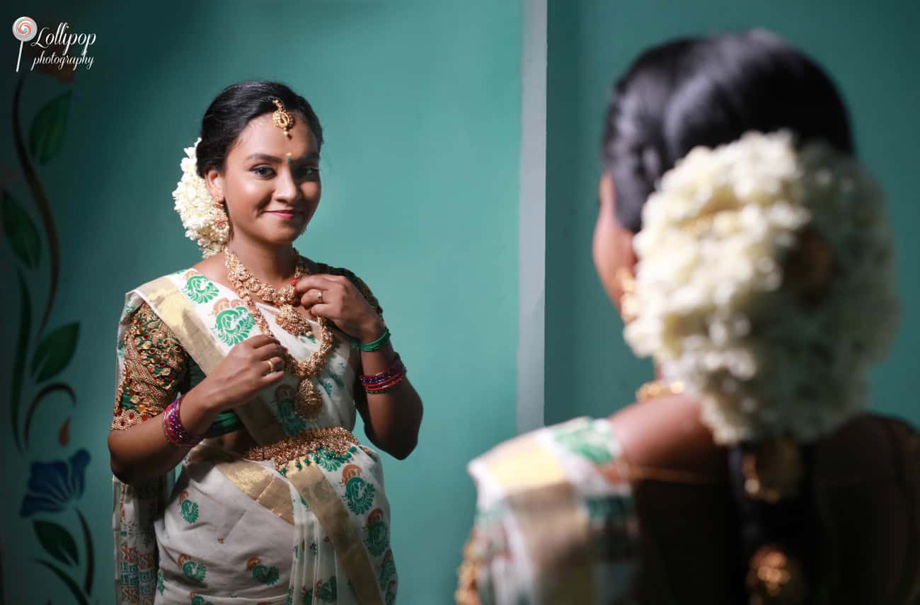 Reflective moment captured of an expectant mother dressed in traditional attire, gazing into a mirror during her maternity photoshoot in Coimbatore.