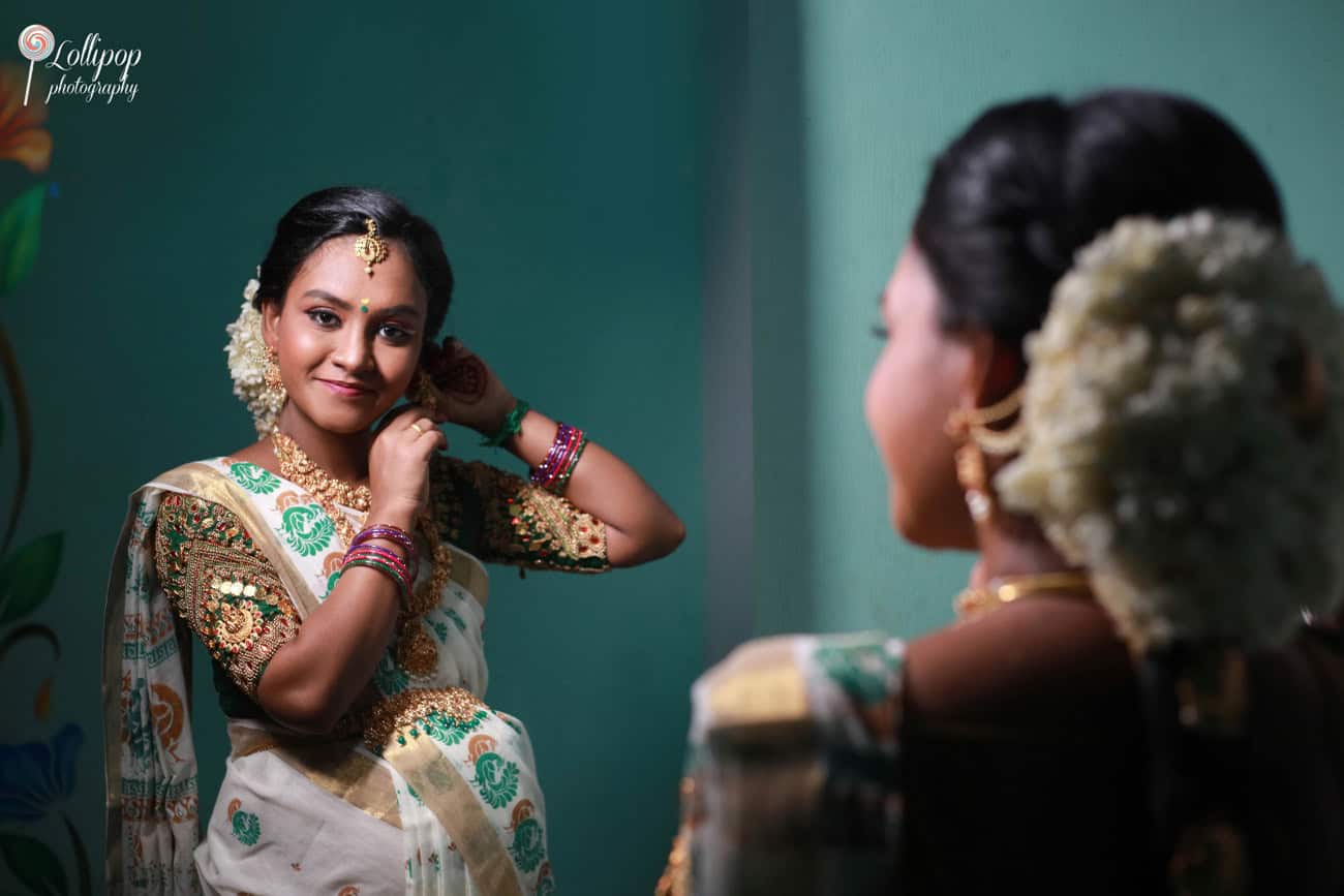 Reflective moment captured of an expectant mother dressed in traditional attire, gazing into a mirror during her maternity photoshoot in Coimbatore.