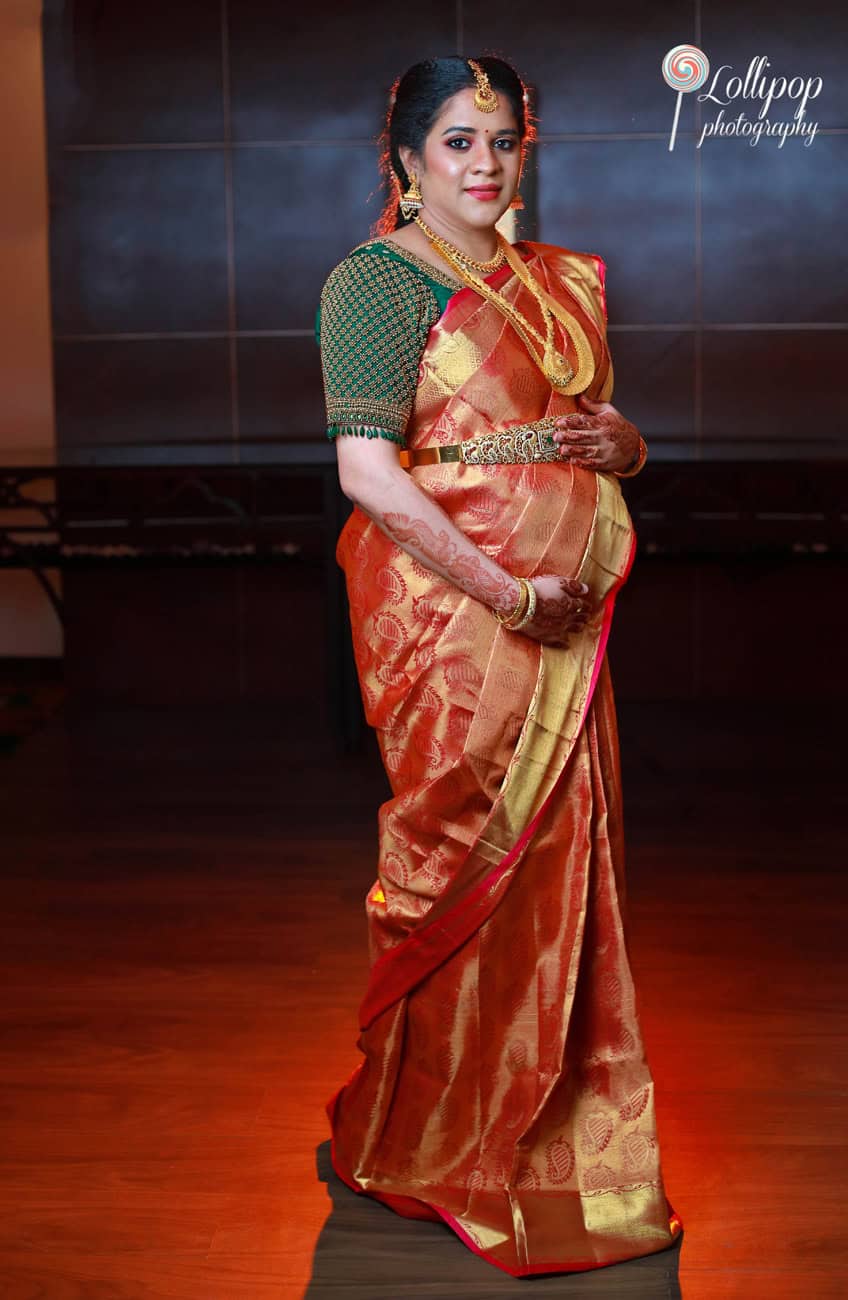 Elegant pregnant woman in traditional South Indian saree adorned with gold jewelry, captured by Lollipop Photography in Chennai