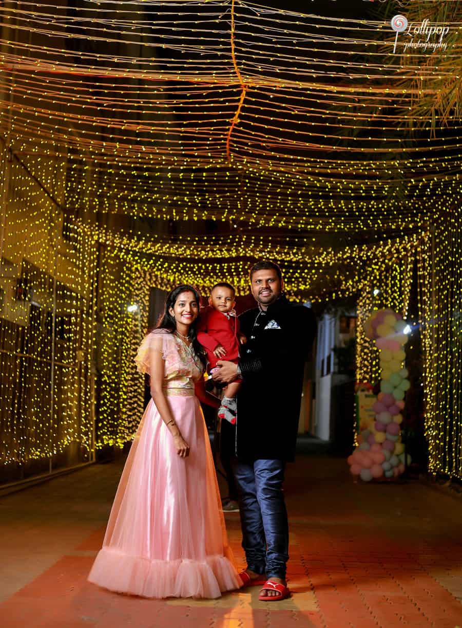 A family stands under a starry string light canopy at a birthday celebration in Chennai, exuding warmth and happiness in their festive attire, beautifully captured by Lollipop Photography