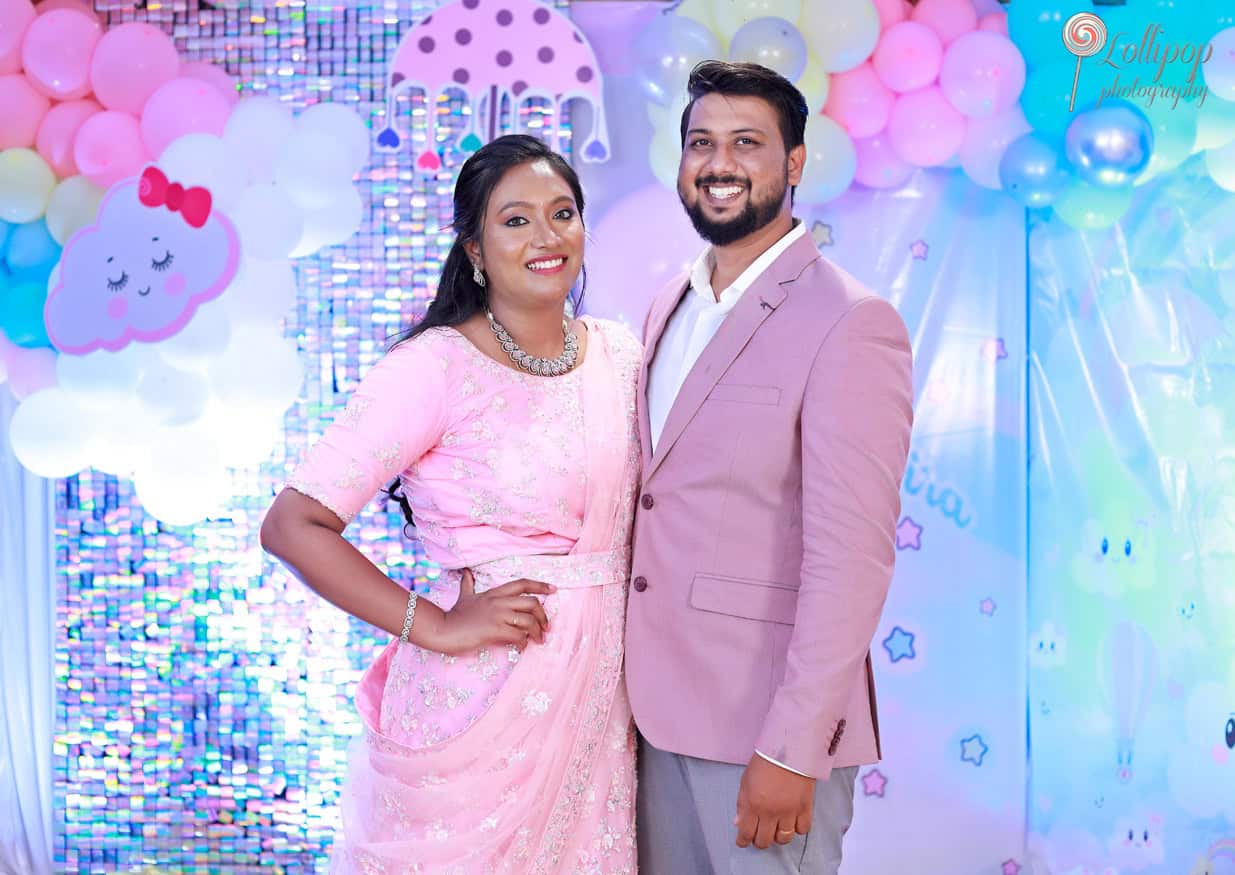 A lovely couple posing in coordinated pink outfits at Kanali's birthday celebration, captured by Lollipop Photography in Chennai.