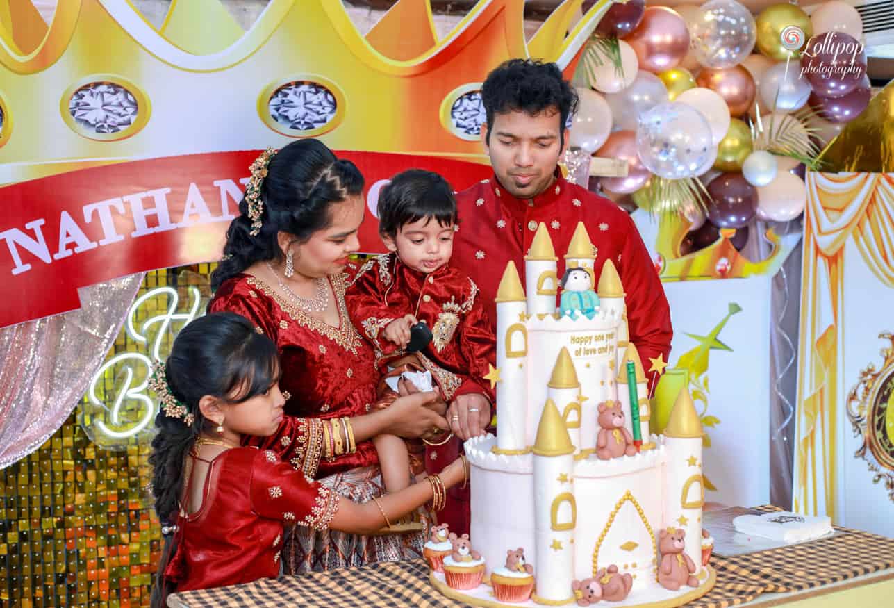 A close-up of Nathaniel’s family engaged in cake-cutting, celebrating his first birthday with joy and laughter.