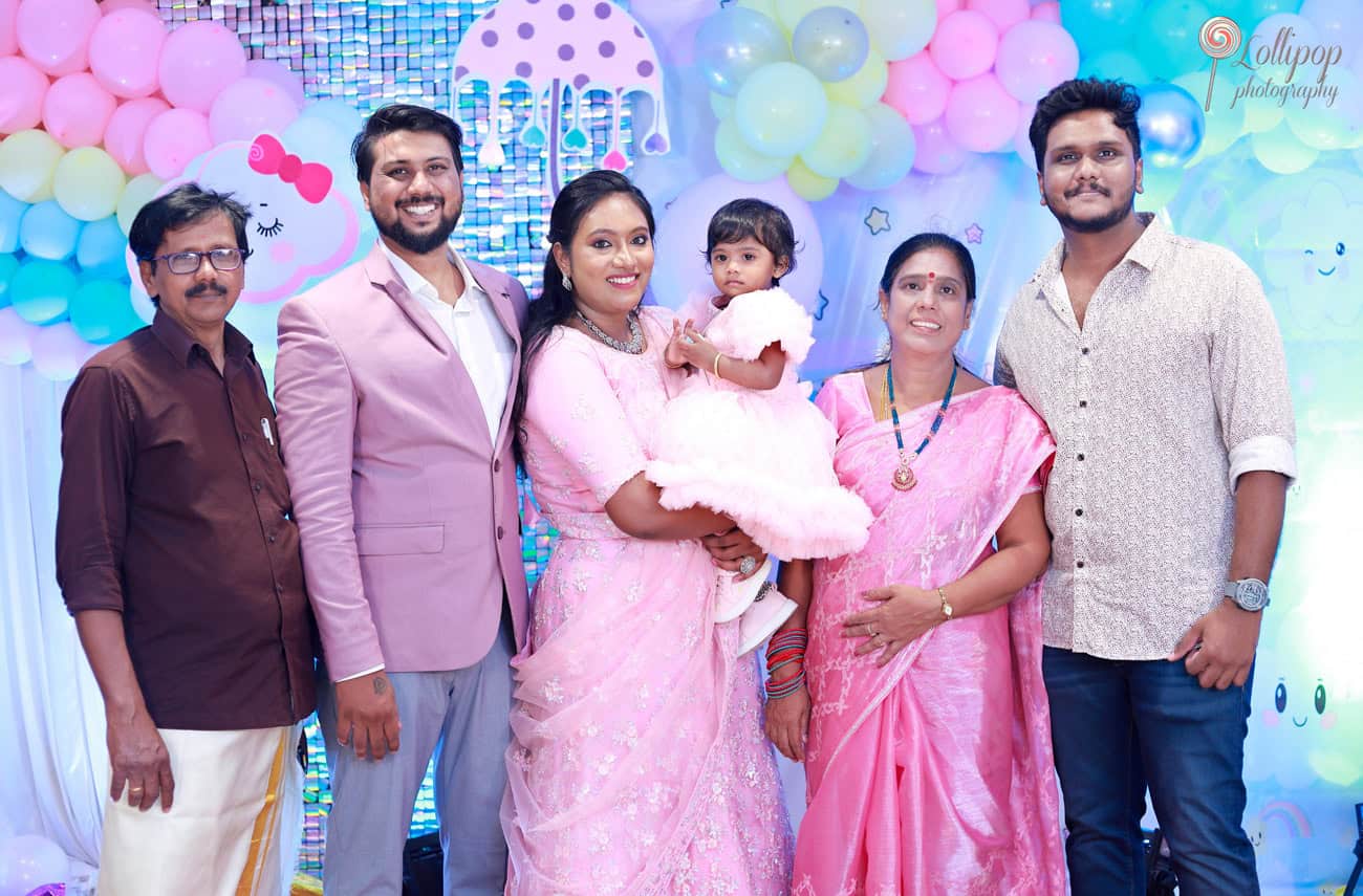 A delightful family moment as Kanali's family gathers to celebrate her birthday, with vibrant decorations and smiles all around, beautifully captured by Lollipop Photography