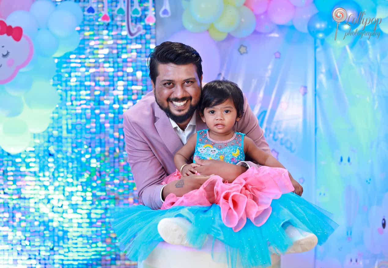 Kanali and her father celebrating her birthday with a bright pink and blue backdrop, captured by Lollipop Photography, Chennai