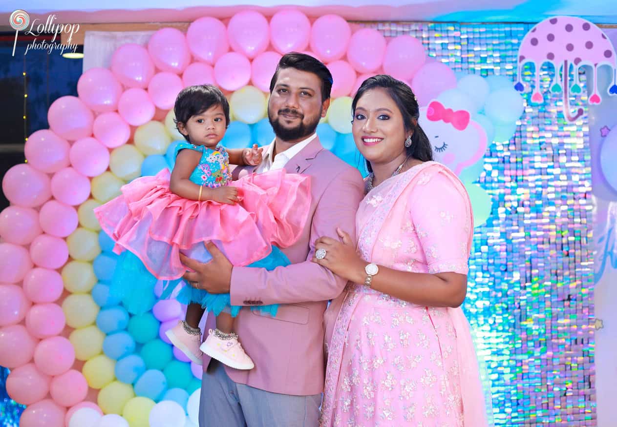 Kanali with her parents in a vibrant pink and blue-themed birthday setup, captured by Lollipop Photography in Chennai