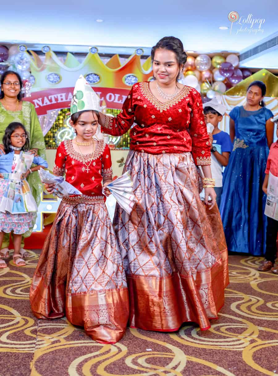 A joyful mother-daughter moment at Nathaniel's birthday event, showcasing traditional attire, beautifully captured by Lollipop Photography