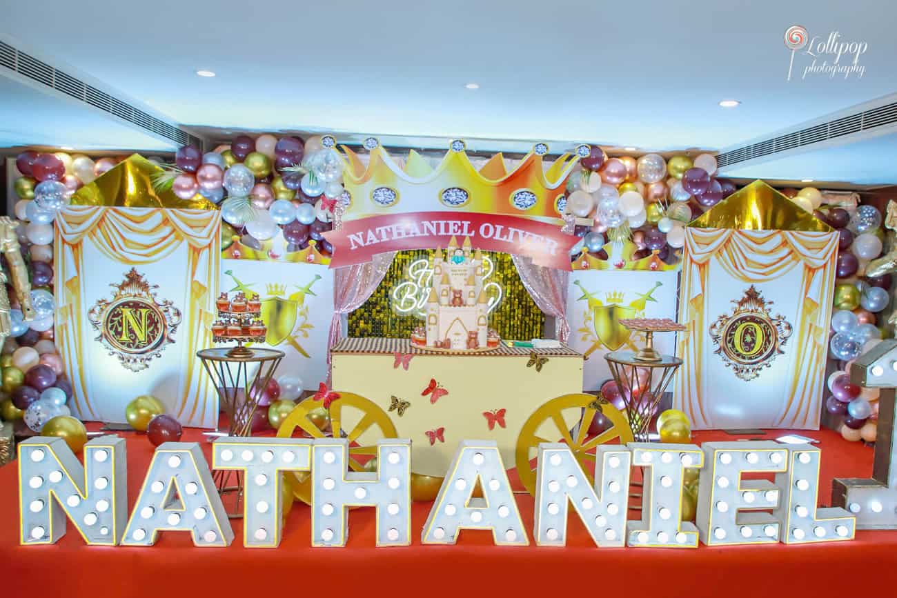 A majestic setup for Nathaniel's birthday, featuring a crown banner with his name and colorful balloon decor, elegantly captured by Lollipop Photography