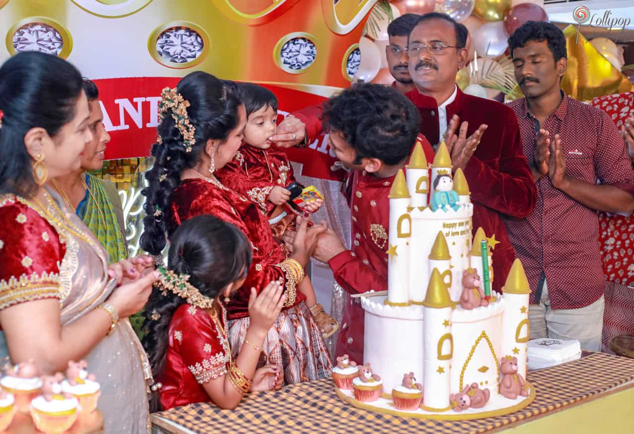 Nathaniel's family gathers closely around the beautifully decorated birthday cake, celebrating a memorable day together