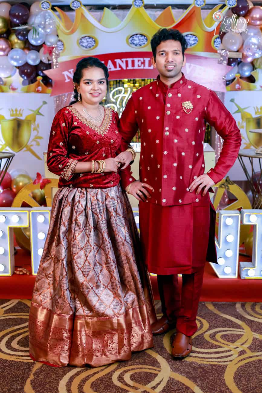 Nathaniel’s parents pose elegantly in traditional attire, adding grace to the birthday celebration backdrop.