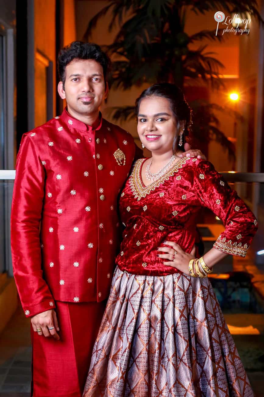 A portrait of Nathaniel's parents, elegantly dressed in matching red and gold outfits, at his birthday celebration, captured by Lollipop Photography.