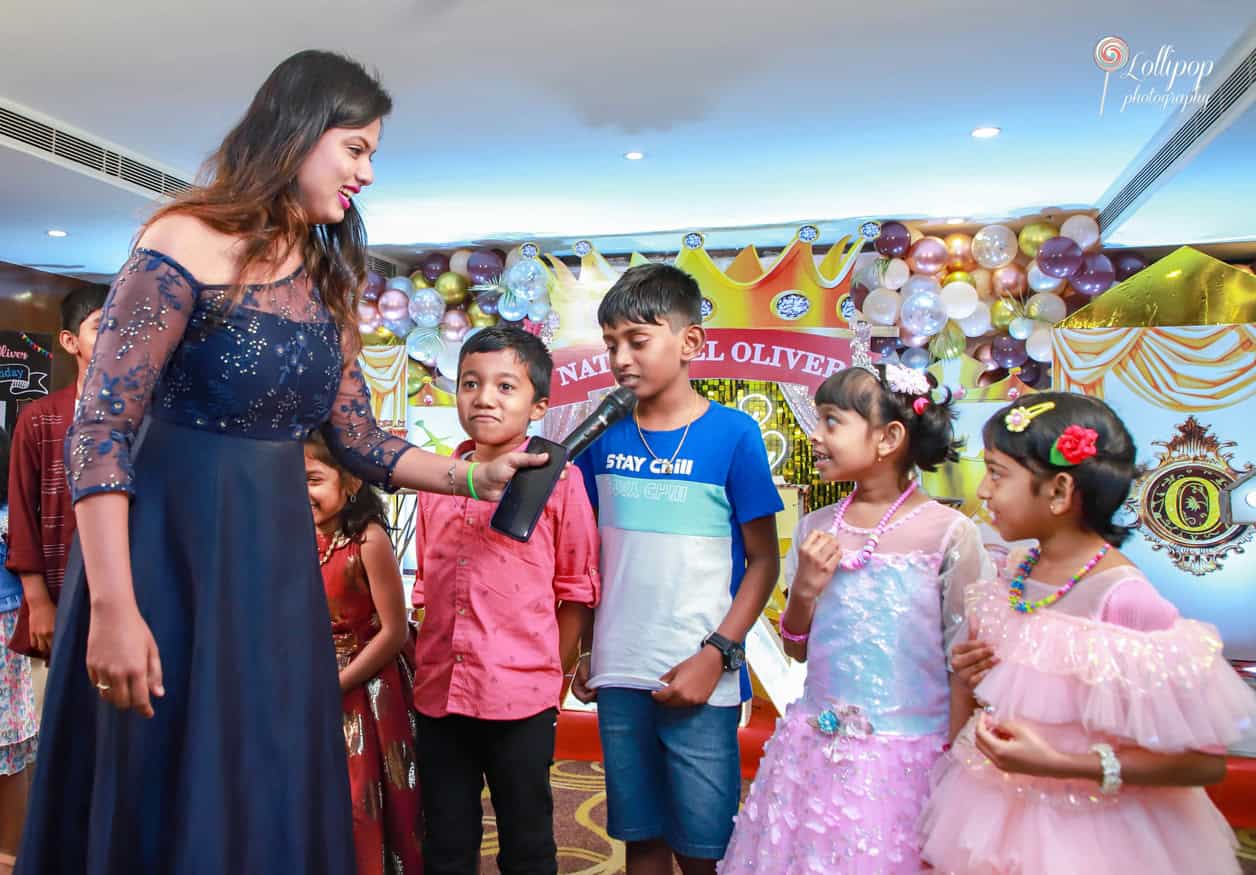 The host engages with the children at Nathaniel's birthday celebration, bringing smiles and excitement, beautifully captured by Lollipop Photography.