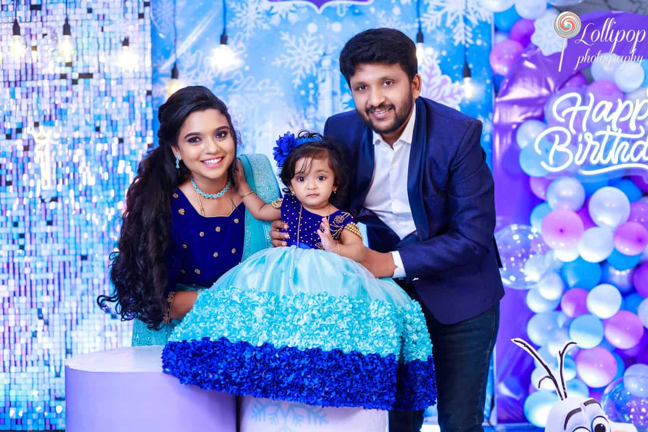 A joyful family moment with Pranika dressed in a festive gown during her birthday celebration, captured by Lollipop Photography.