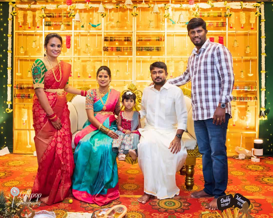 Arthi and Naveen Kumar with close friends at their baby shower celebration in Chennai, highlighting vibrant decor and happy moments, captured by Lollipop Photography