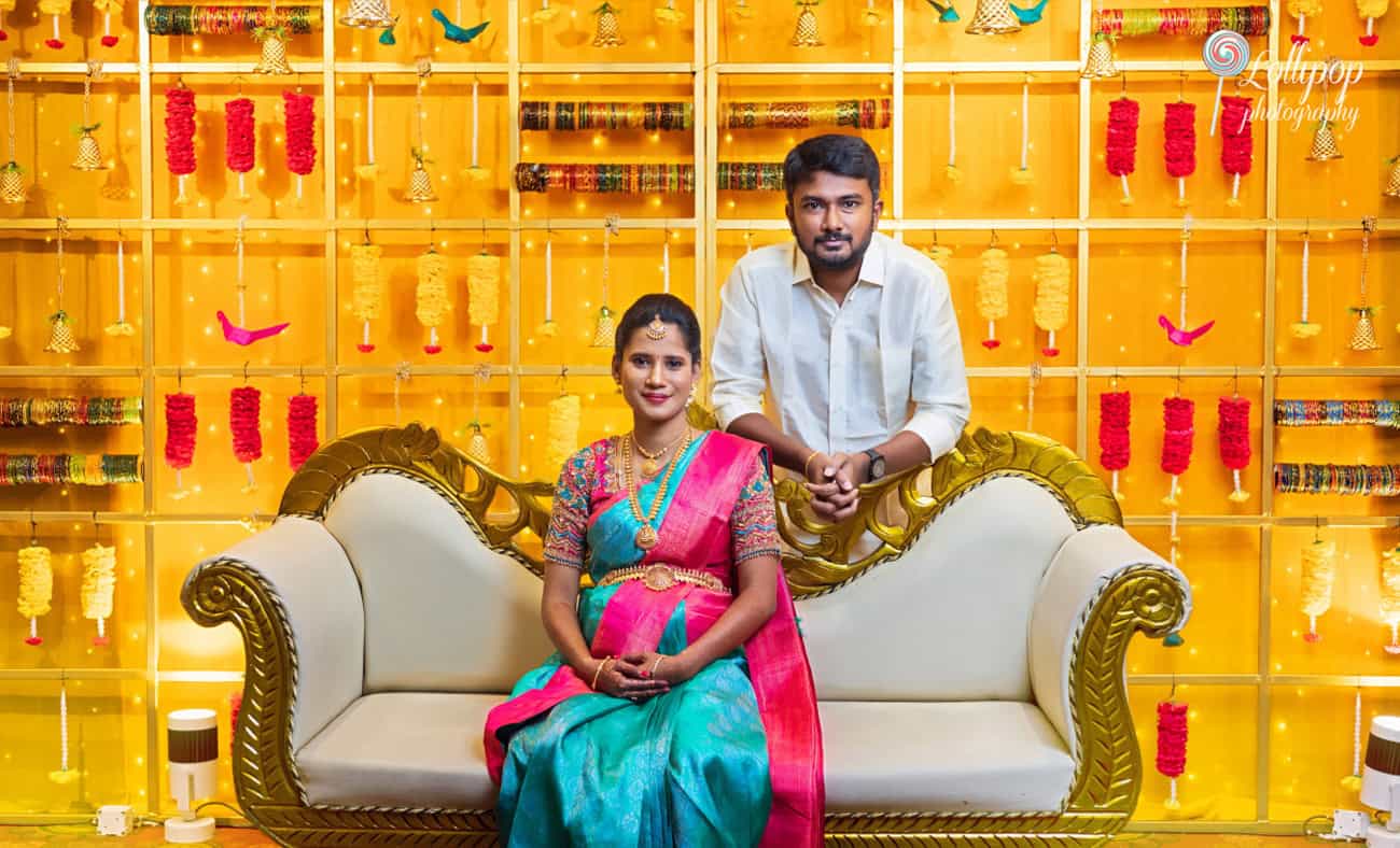 Elegant baby shower setting in Chennai with Arthi and Naveen Kumar seated against a beautiful traditional backdrop, captured by Lollipop Photography