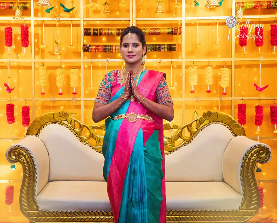 Arthi greeting with folded hands in a traditional pose during her baby shower, adorned in vibrant attire, taken in Chennai by Lollipop Photography