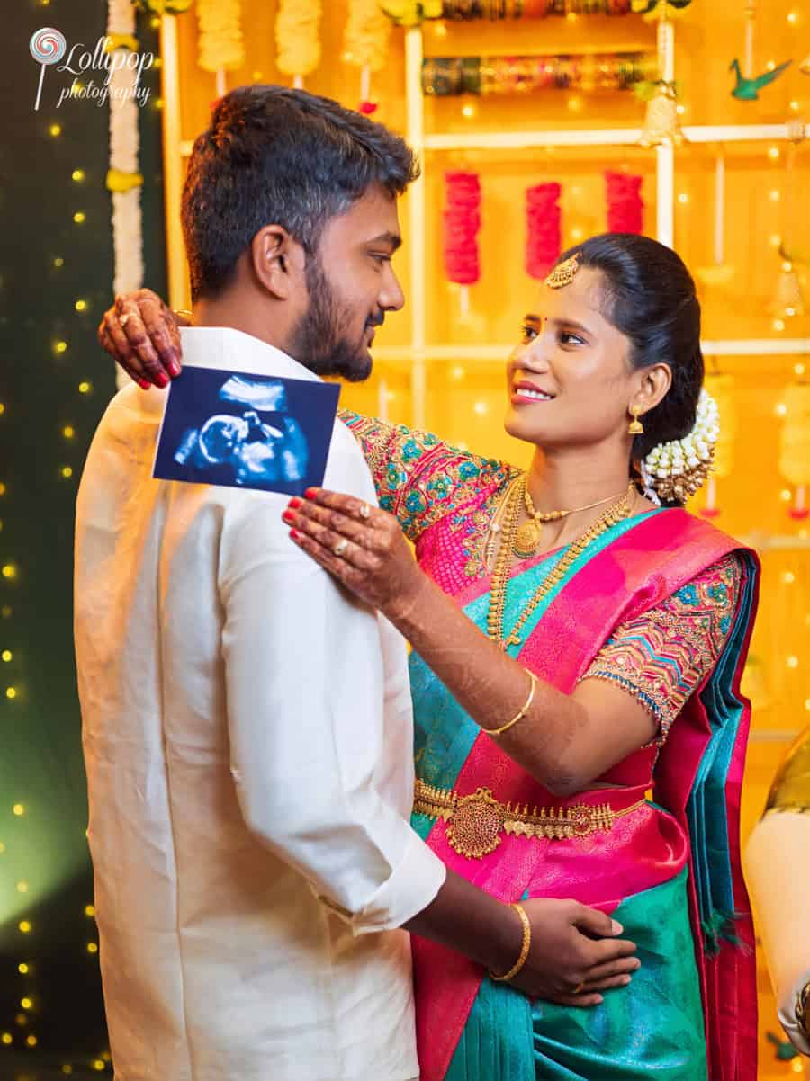 Heartwarming moment of a couple at a baby shower, holding an ultrasound photo, photographed by Lollipop Photography in Chennai.