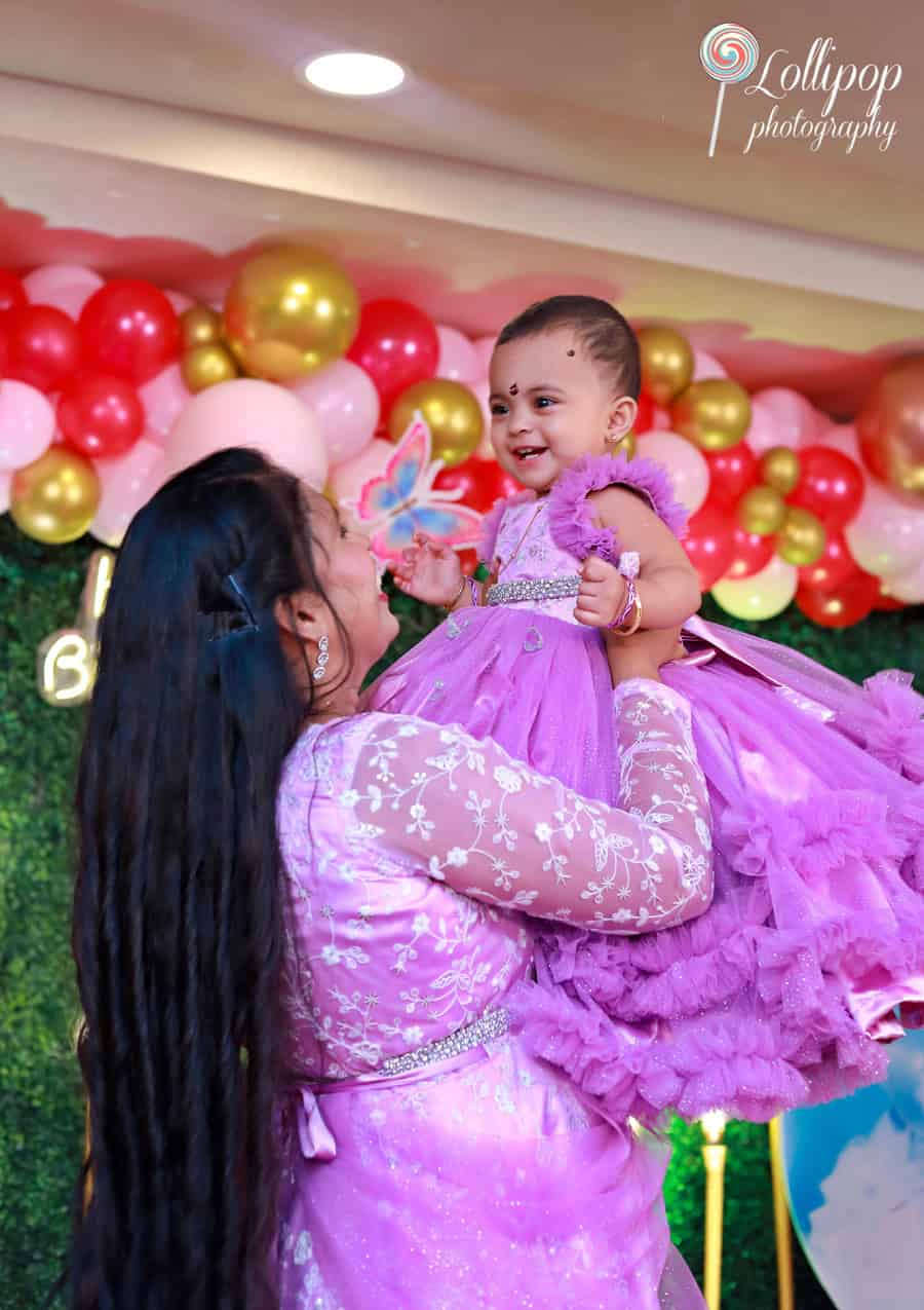 A joyful moment as the mother lifts her smiling baby girl during her butterfly-themed birthday celebration. Birthday photoshoot by Lollipop Photography, Chennai