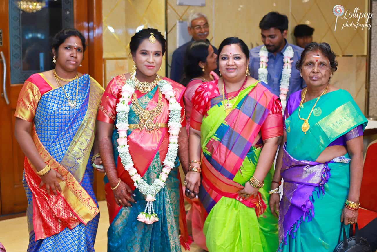 Aswini stands gracefully with her family members during her baby shower celebration in Chennai, surrounded by smiles and traditional attire, captured by Lollipop Photography