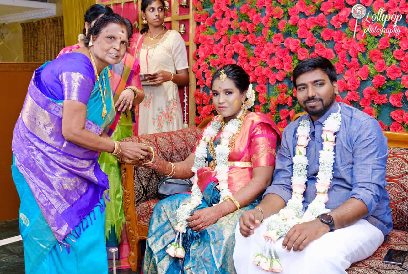 An elder blesses Aswini during her baby shower in Chennai, symbolizing family love and tradition, beautifully captured by Lollipop Photography