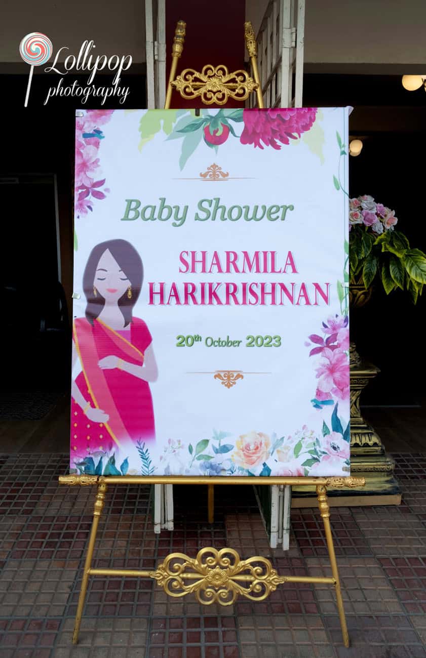 Beautiful welcome board at Sharmila's baby shower celebration, adorned with floral accents, captured in Coimbatore by Lollipop Photography