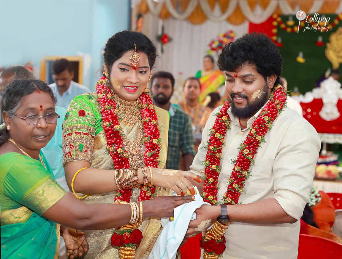 Anitha and her husband receive blessings from a family member, celebrating the joy of their baby shower in Coimbatore