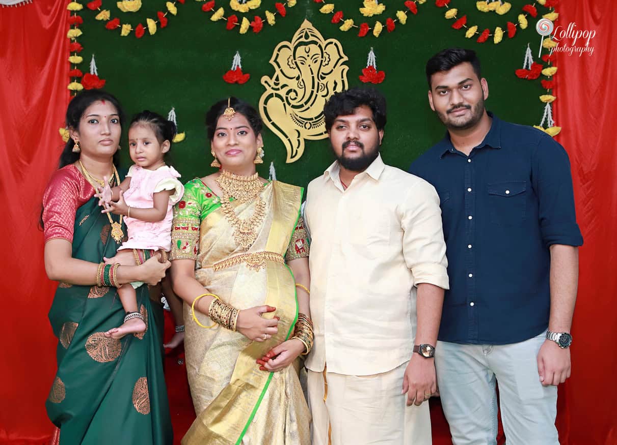 Anitha poses with her family in a beautiful setting, a cherished moment captured by Lollipop Photography in Coimbatore