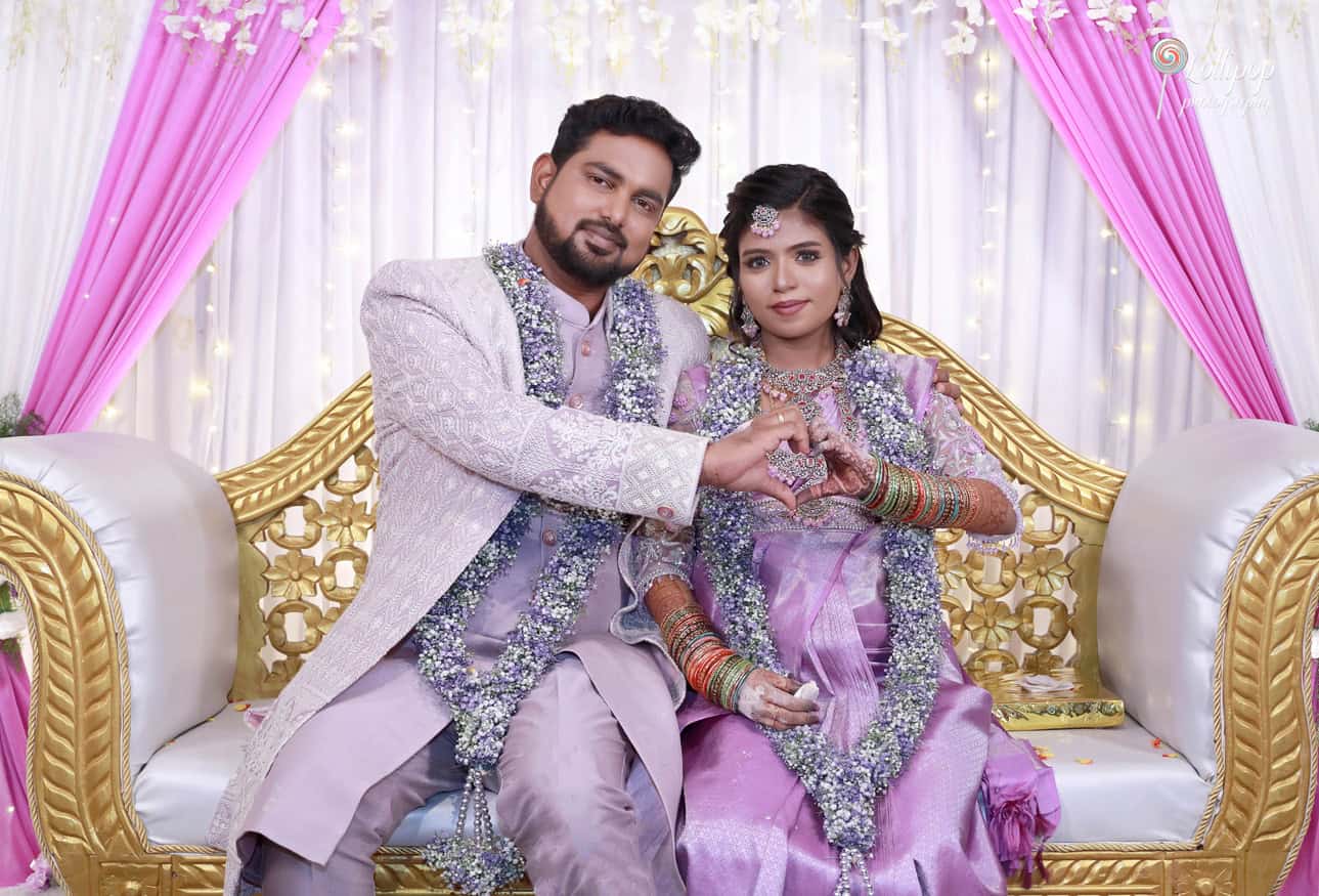 The expecting couple shares a heartfelt moment, forming a heart gesture with their hands, symbolizing love and anticipation for their new arrival.