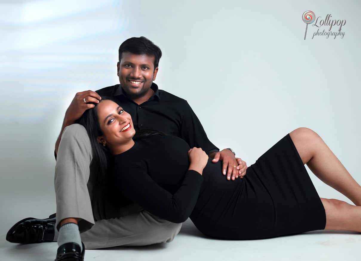 Pavithra and her husband share a relaxed portrait, celebrating the joy of parenthood in a studio maternity photoshoot by Lollipop Photography in Chennai