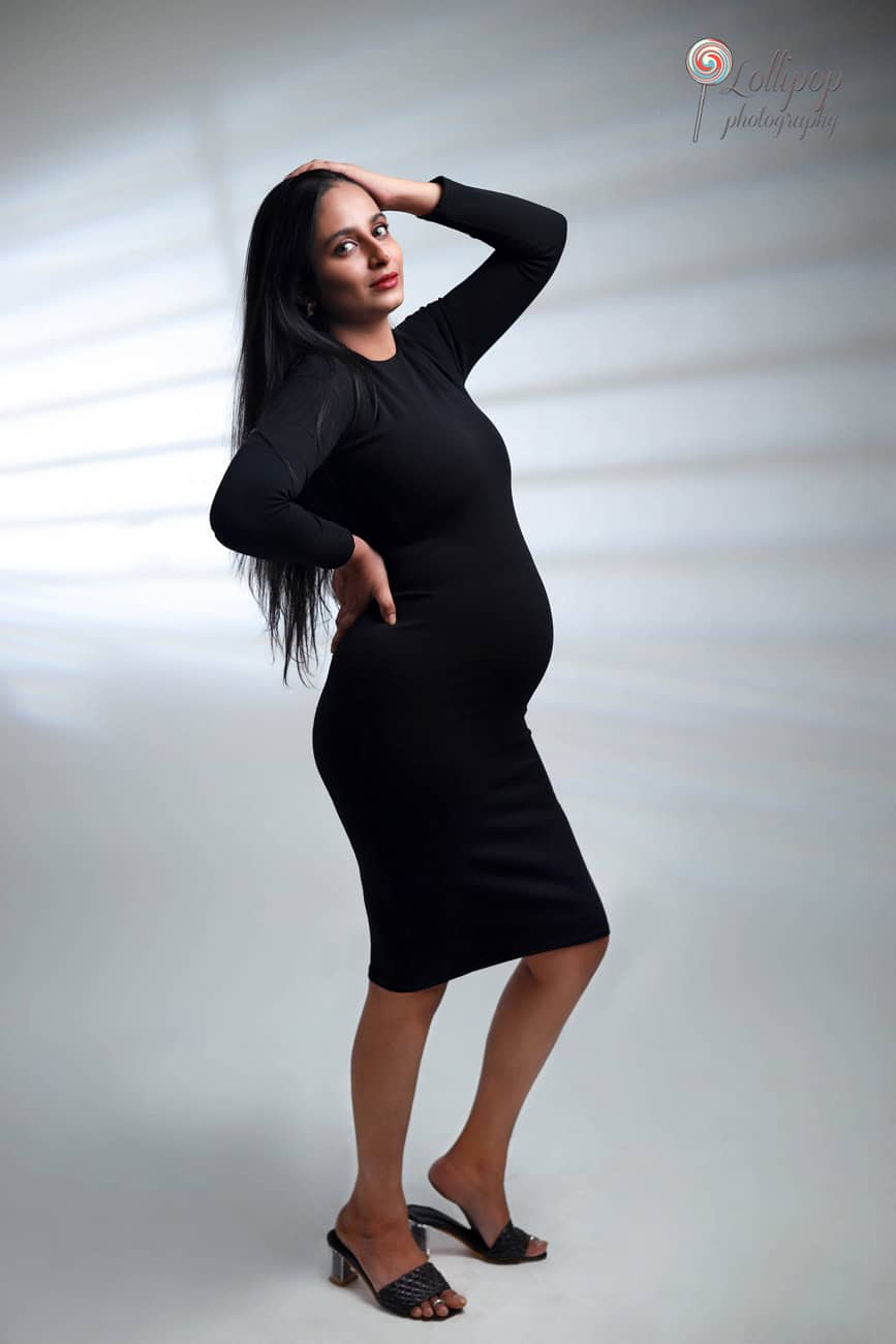 Pavithra stands elegantly in a flowing blue gown, embracing her pregnancy in a serene maternity photography session in Chennai