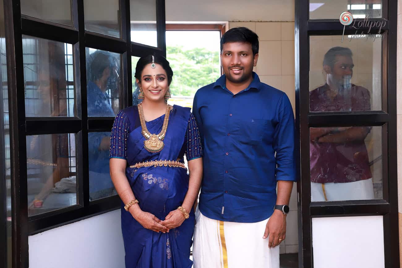 A tender moment shared by the expectant couple dressed in blue during their baby shower photoshoot, captured by Lollipop Photography in Coimbatore.