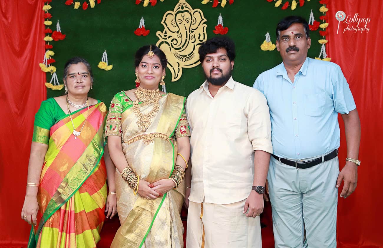 Anitha and her husband pose with family members, receiving blessings for their upcoming arrival, beautifully captured by a photographer in Coimbatore