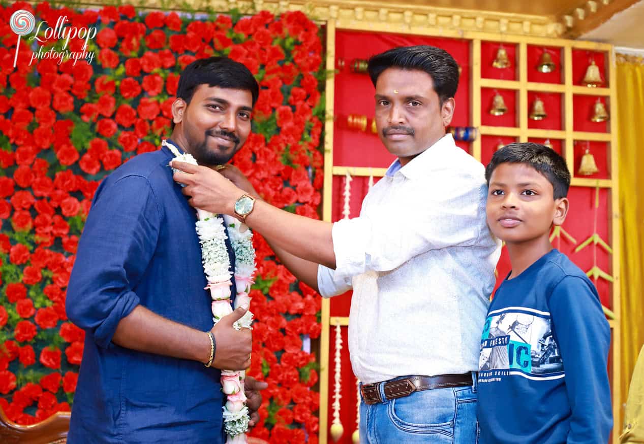 Family members garland Aswini and Naresh, symbolizing blessings and good wishes, during the baby shower ceremony in Chennai, by Lollipop Photography