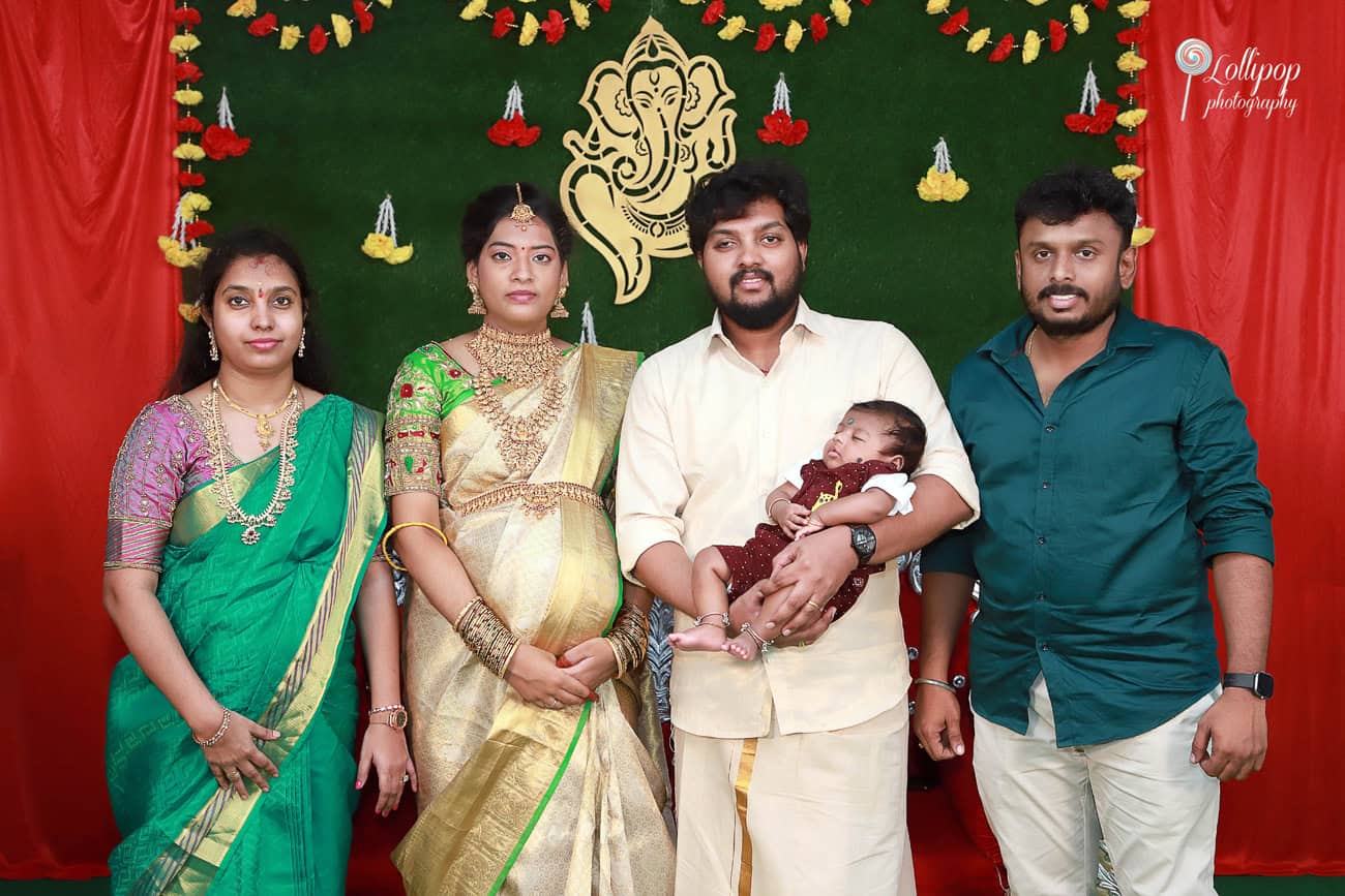 Anitha and her husband pose with family members, surrounded by blessings and joy during the baby shower celebration in Coimbatore.