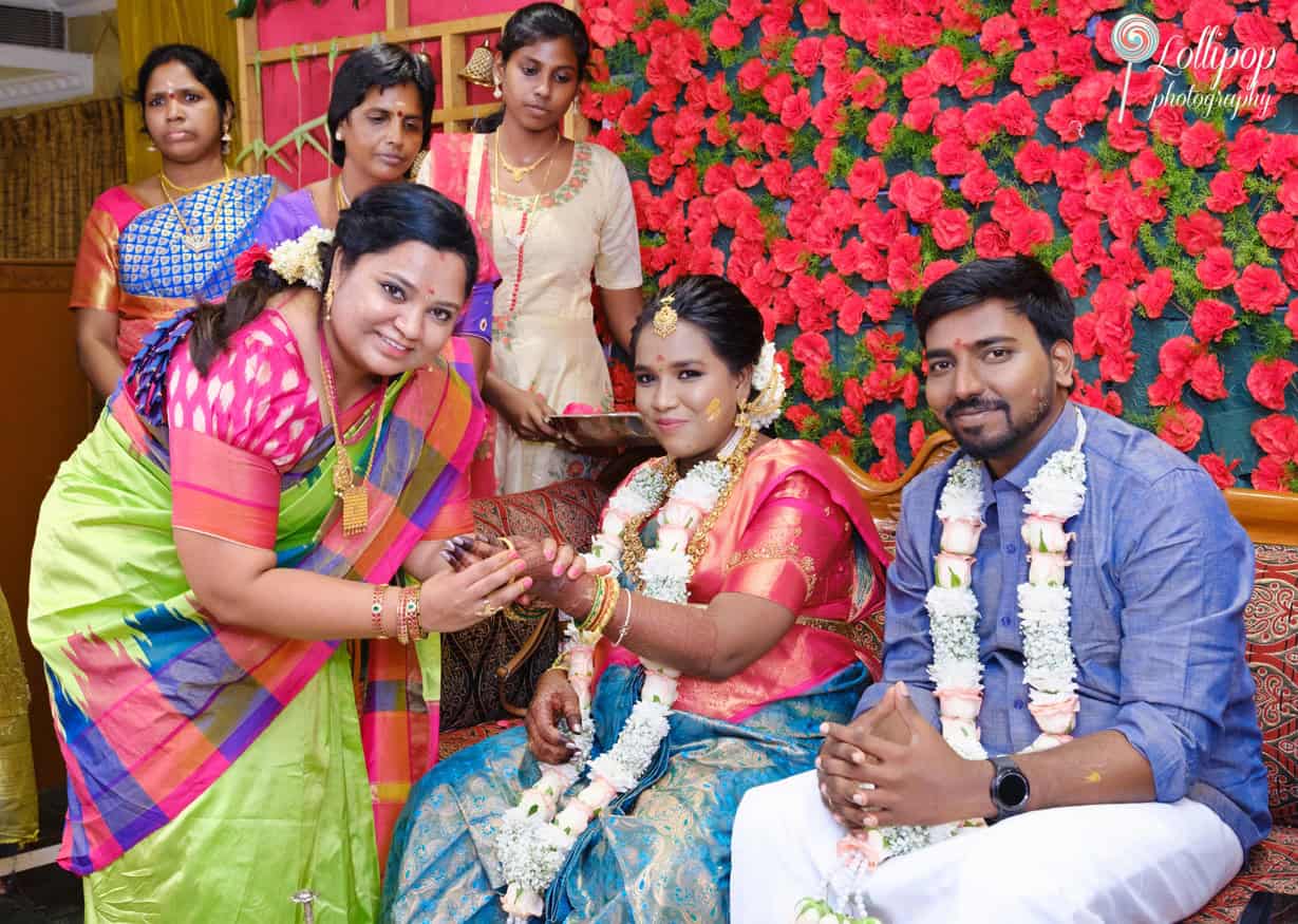 Friends and family join in the joyous celebration of Aswini’s baby shower, offering their blessings and gifts in a lively, colorful setting in Chennai