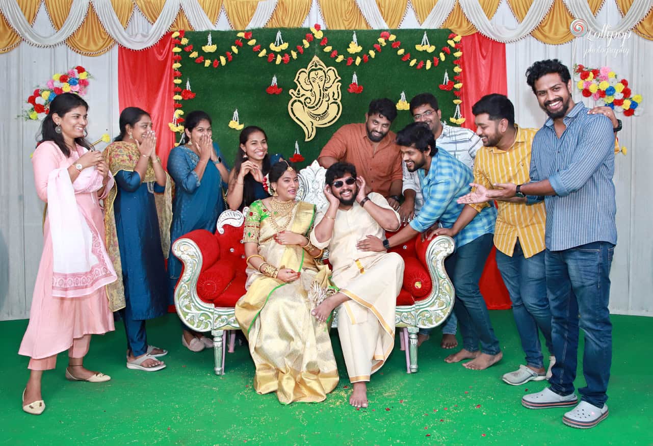 Anitha and her husband share a playful moment with friends at the baby shower celebration, captured by a photographer in Coimbatore.