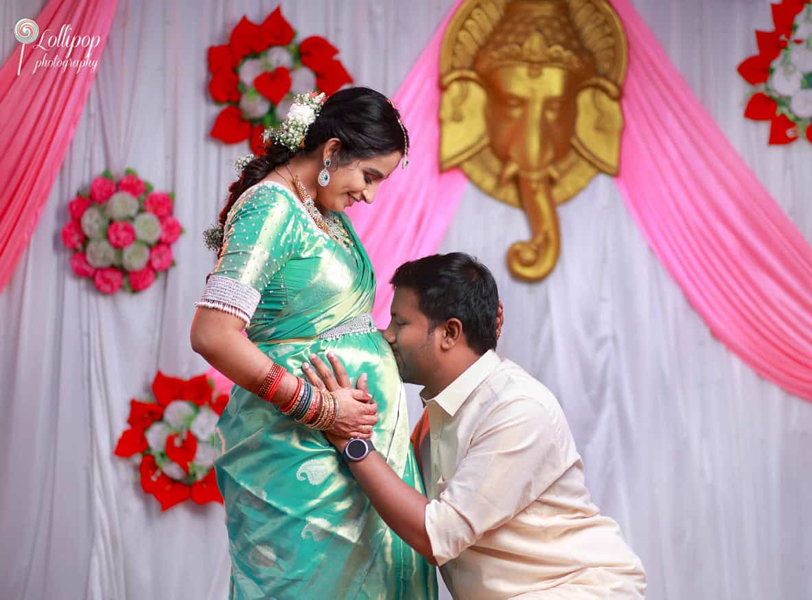 A heartwarming moment as the husband cherishes Pavithra’s baby bump, captured during their traditional baby shower ceremony in Coimbatore