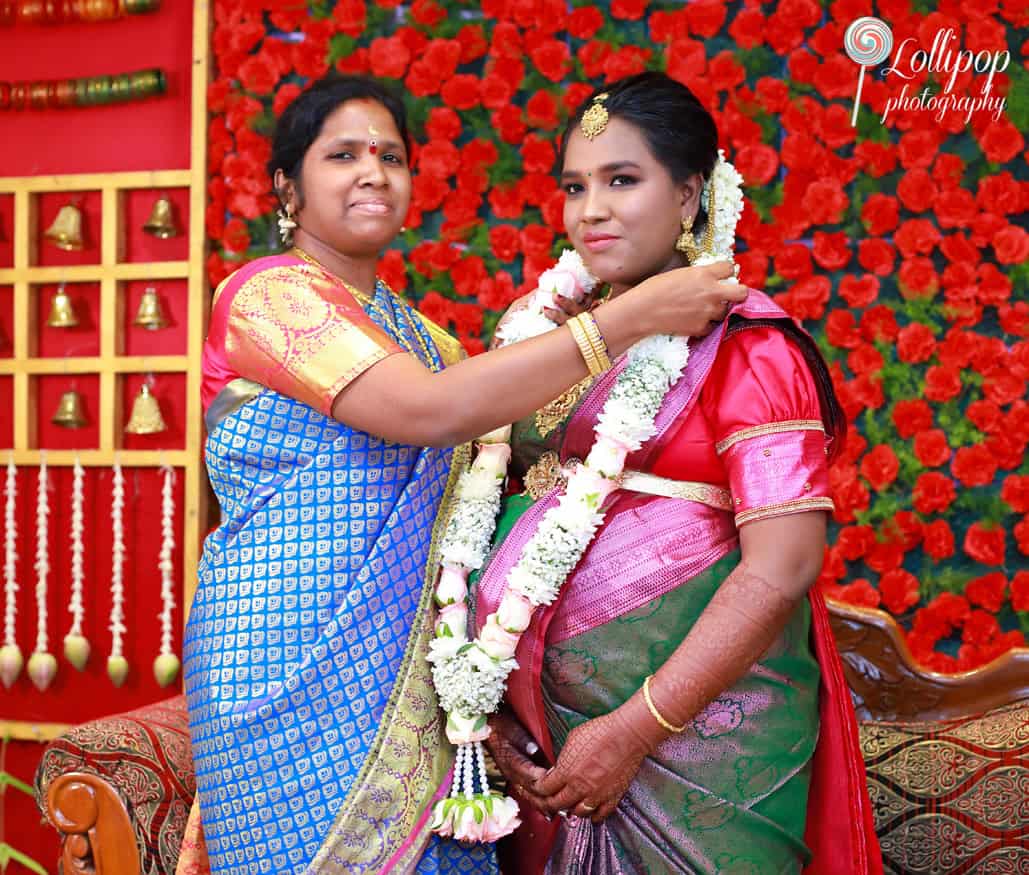 Aswini’s mother lovingly garlands her daughter in a heartfelt moment at the baby shower in Chennai, beautifully captured by Lollipop Photography