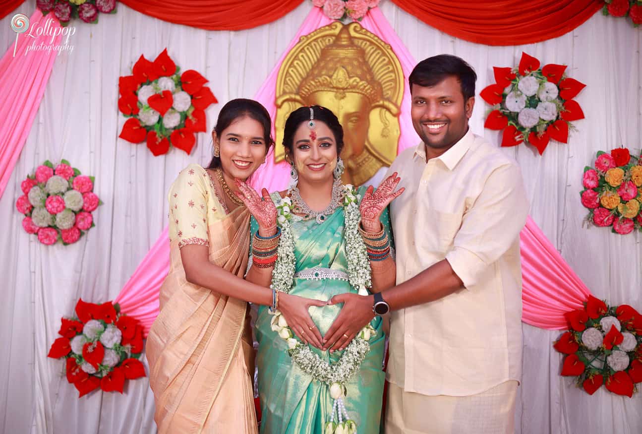 Pavithra and her family lovingly form a heart around her belly, radiating joy and anticipation during the baby shower event in Coimbatore.