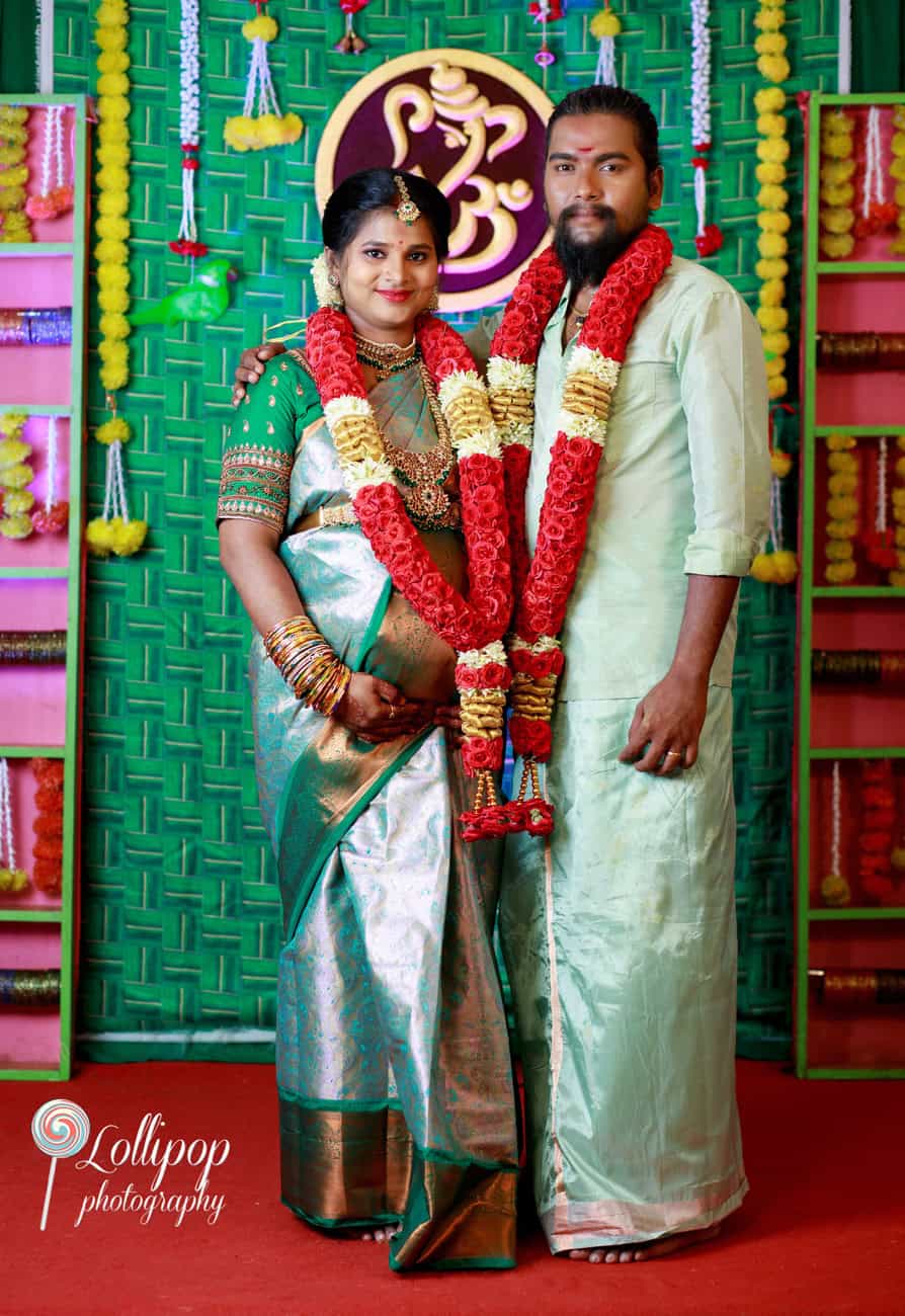 A beautiful portrait of Sharmila and her husband, both wearing traditional floral garlands, during her baby shower ceremony in Coimbatore, captured by Lollipop Photography.