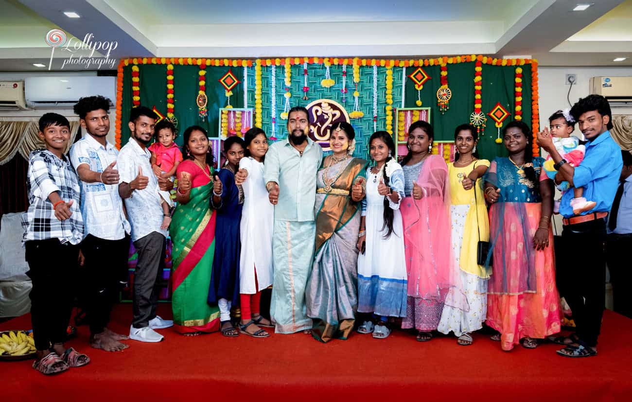 A joyous group photo with Sharmila and family celebrating her baby shower, all giving a thumbs-up in colorful traditional attire, captured by Lollipop Photography in Coimbatore.