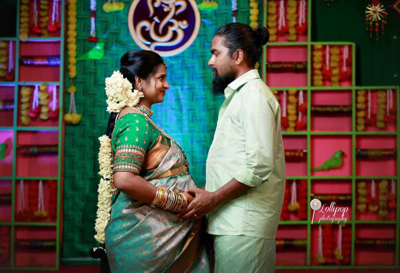 Sharmila lovingly gazes at her husband during her baby shower celebration in Coimbatore, captured by Lollipop Photography.