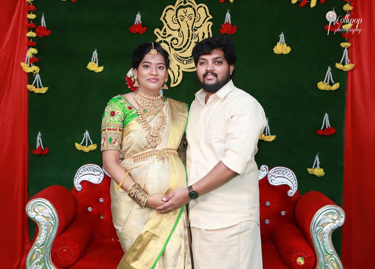 Anitha and her husband in traditional attire, posing for a memorable photo during their baby shower in Coimbatore.